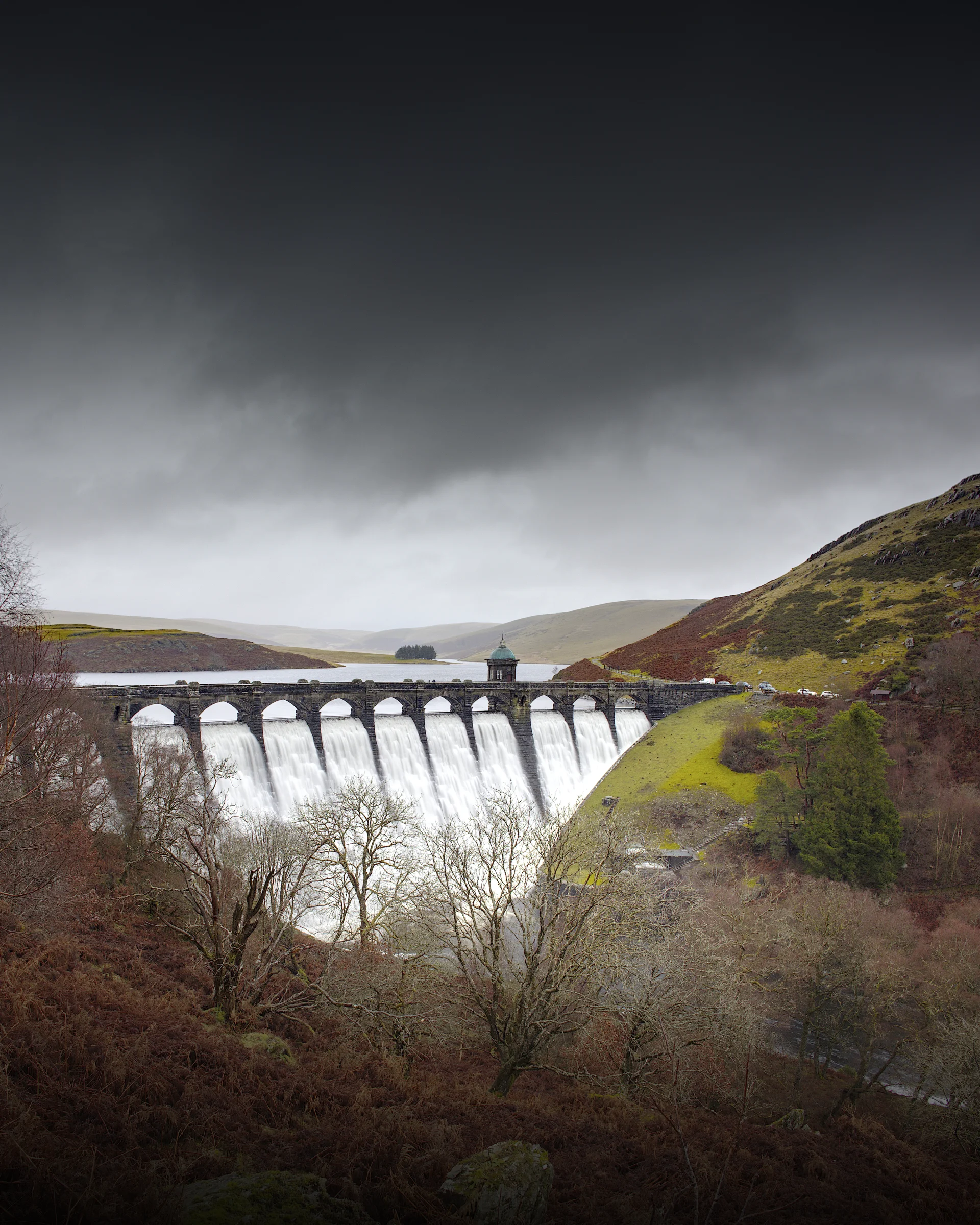 There's a strong chance this image contains the following subjects: sky,  water,  landscape,  lake,  nature,  river,  bridge,  storm,  waterfall,  wales,  locomotive,  craiggoch,  craiggochdam,  elanvalley,  powys,  dam. The photographer has provided the following description: In the heart of the Elan Valley is Craig Goch Dam. Absolutely stunning part of the world.  Photographer_name: Chris Michael. Title: Craig Goch Dam. The photographer has provided the following description: In the heart of the Elan Valley is Craig Goch Dam. Absolutely stunning part of the world.  Make: canon. Model: EOS R. Technical: 70-200mm. Published: 2025-09-09 13:50:31