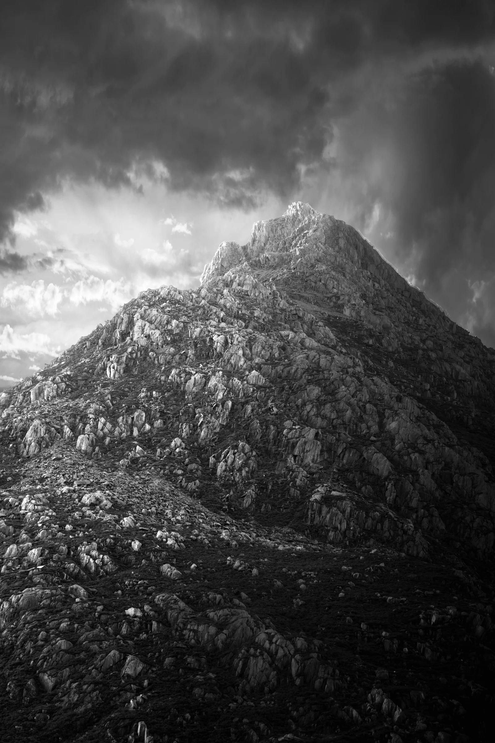 There's a strong chance this image contains the following subjects: sky,  monochrome,  landscape,  travel,  nature,  blackandwhite,  snowdonia,  eryri,  eryrinationalpark,  nationalpark,  snowdon,  tryfan. The photographer has provided the following description: Taken in Snowdonia 2024, this is the mighty Tryfan mountain. Photographer_name: Chris Michael. Title: The Mighty Tryfan. The photographer has provided the following description: Taken in Snowdonia 2024, this is the mighty Tryfan mountain. Make: fujifilm. Model: X-T5. Technical: 55-200mm. Published: 2025-09-09 16:08:31