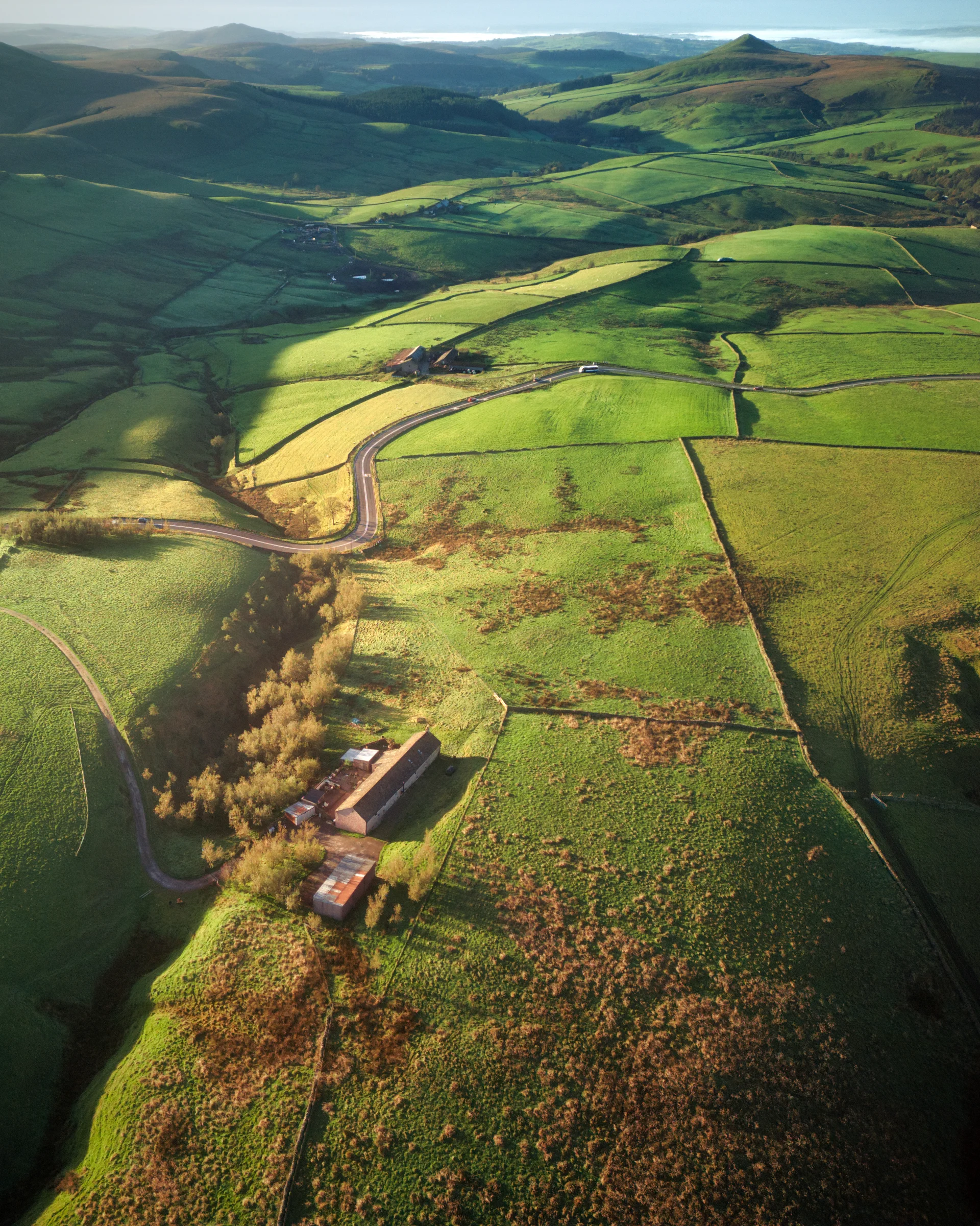 There's a strong chance this image contains the following subjects: landscape,  cropland,  field,  farm,  agriculture,  cheshire,  shutlingsloe. The photographer has provided the following description: Taken from a drone. A panoramic shot of the Cheshire landscape out towards Shutlingsloe. Photographer_name: Chris Michael. Title: Shining Tor. The photographer has provided the following description: Taken from a drone. A panoramic shot of the Cheshire landscape out towards Shutlingsloe. Make: dji. Model: Mavic 2 Pro. Published: 2025-09-05 19:05:54