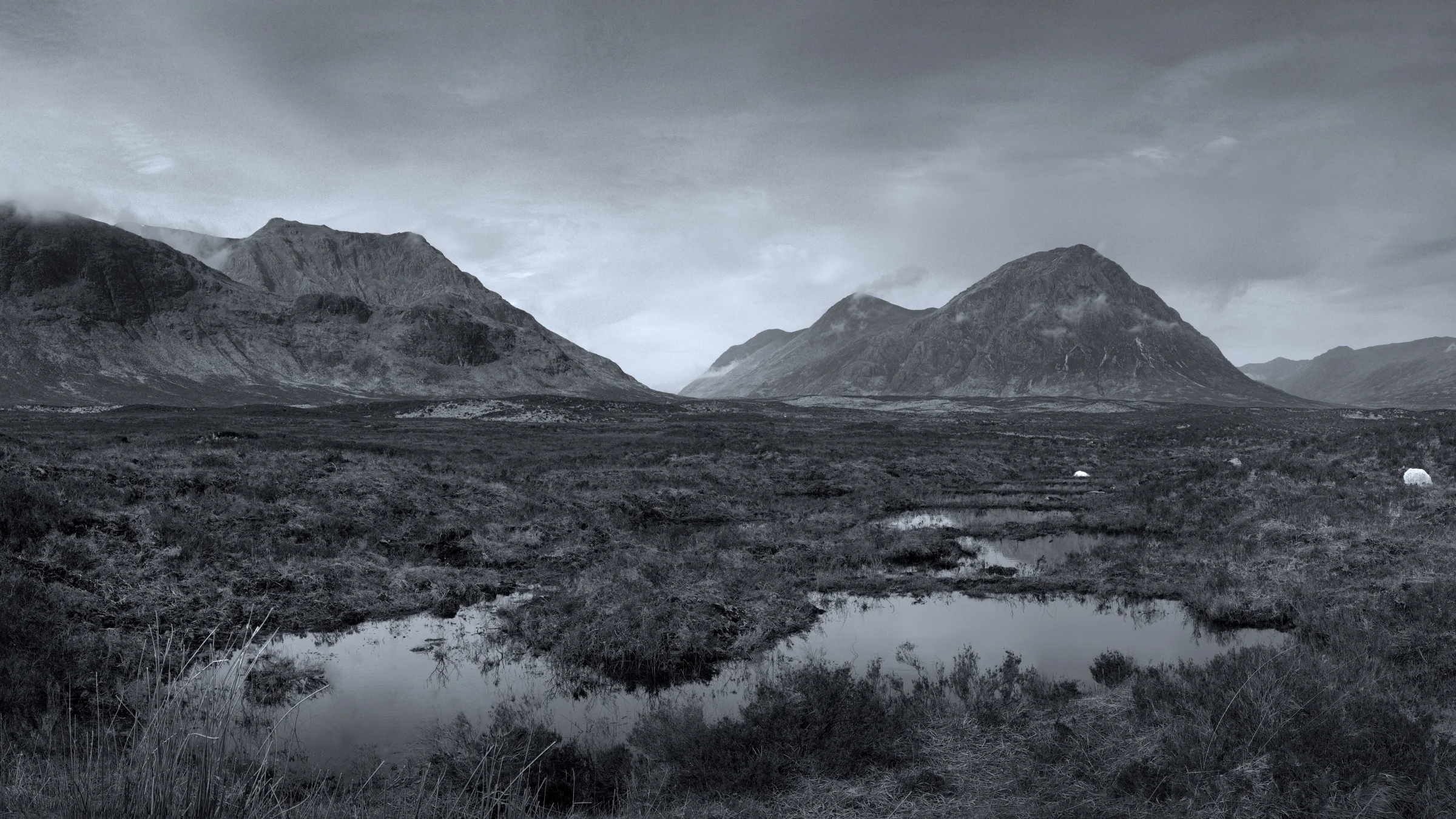 There's a strong chance this image contains the following subjects: monochrome,  water,  landscape,  lake,  nature,  scotland,  highlands,  scottishhighlands,  blackandwhite,  buachailleetivemor,  glencoe,  reflections. The photographer has provided the following description: Rannoch Moor looking towards the Buachaille, from Glencoe Mountain Resort. An 8 shot panoramic photo. Photographer_name: Chris Michael. Title: Rannoch Moor. The photographer has provided the following description: Rannoch Moor looking towards the Buachaille, from Glencoe Mountain Resort. An 8 shot panoramic photo. Make: fujifilm. Model: X-T5. Technical: 16-80mm. Published: 2025-09-08 21:31:17