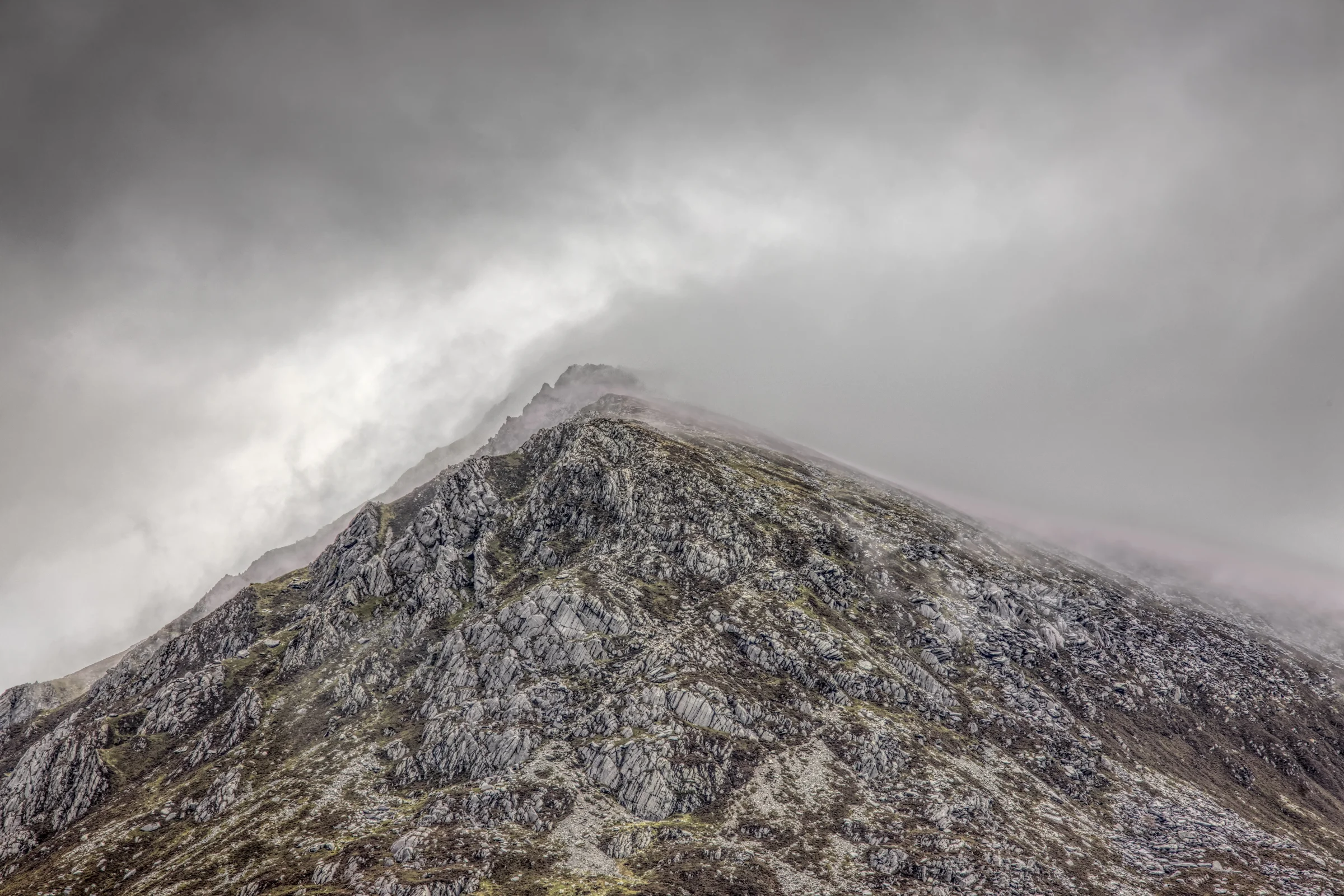 There's a strong chance this image contains the following subjects: sky,  landscape,  travel,  rock,  snowdonia,  eryri,  eryrinationalpark,  nationalpark,  snowdon,  penyrolewen. The photographer has provided the following description: Taken in snowy and cloudy conditions. I love the layers high up on the peak of Pen Yr Ole Wen.  Photographer_name: Chris Michael. Title: Pen Yr Ole Wen Summit. The photographer has provided the following description: Taken in snowy and cloudy conditions. I love the layers high up on the peak of Pen Yr Ole Wen.  Make: fujifilm. Model: X-T5. Technical: 16-80mm. Published: 2025-09-09 16:14:16