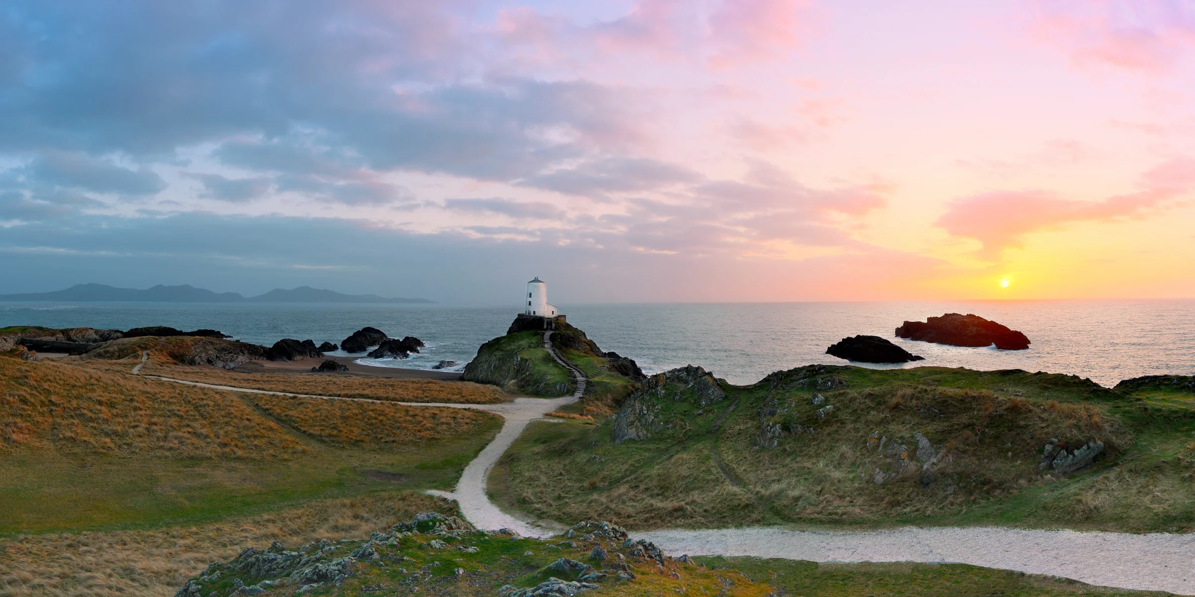 There's a strong chance this image contains the following subjects: water,  landscape,  sea,  sunset,  beach,  lighthouse,  ocean,  seashore,  anglesey,  wales. The photographer has provided the following description: An 8 shot panoramic photo of Llanddwyn Island in Anglesey, North Wales. Taken at sunset. Stitched in Affinity Photo. Photographer_name: Chris Michael. Title: Llanddwyn Island. The photographer has provided the following description: An 8 shot panoramic photo of Llanddwyn Island in Anglesey, North Wales. Taken at sunset. Stitched in Affinity Photo. Make: fujifilm. Model: X-T5. Technical: 16-80mm. Published: 2025-09-09 13:31:18