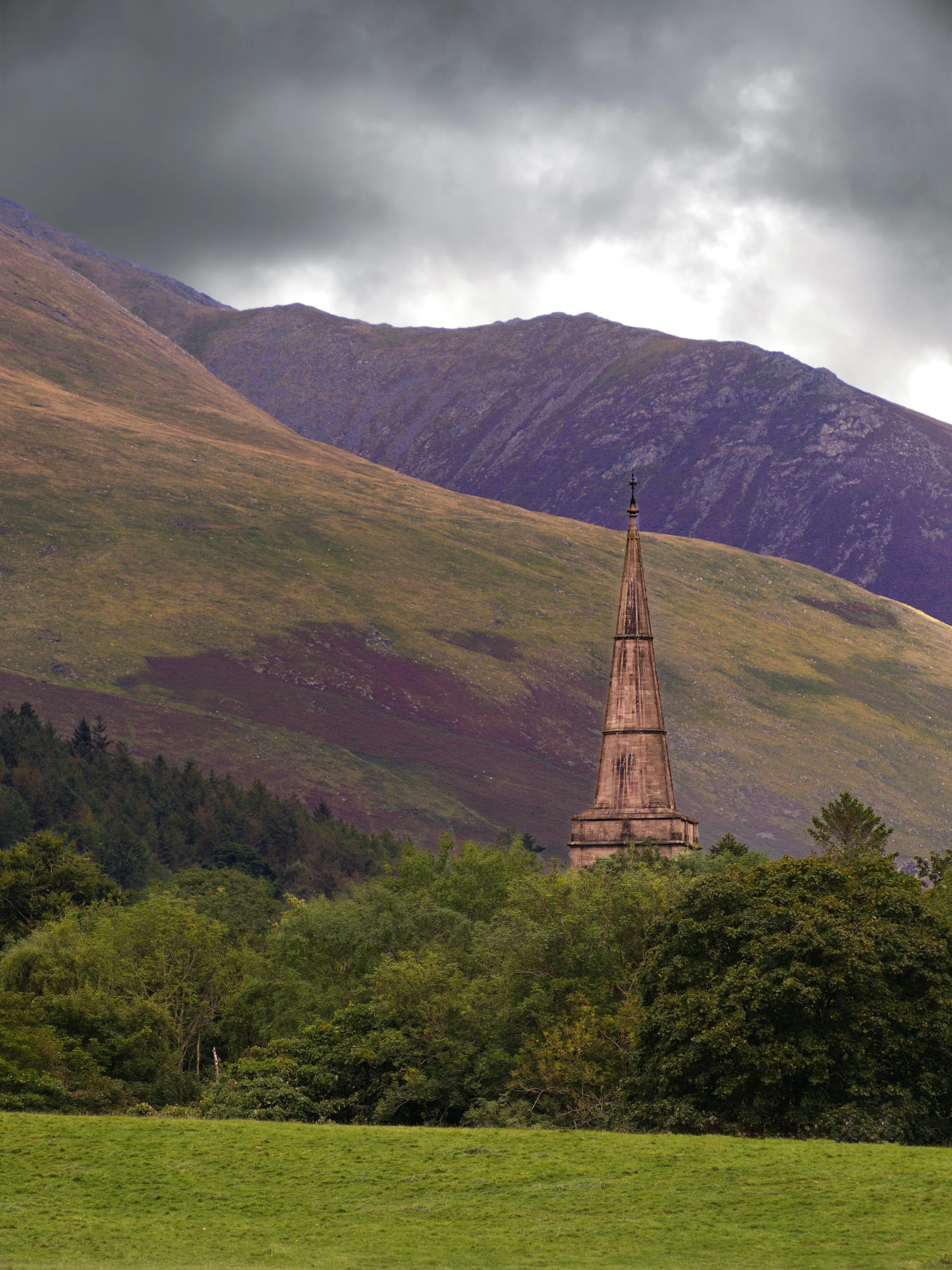 There's a strong chance this image contains the following subjects: sky,  landscape,  travel,  nature,  cumbria,  lakedistrict,  church. The photographer has provided the following description: Behind Hope Park in Keswick, Cumbria is St John's Church. This was take from across Derwentwater. Photographer_name: Chris Michael. Title: The Church. The photographer has provided the following description: Behind Hope Park in Keswick, Cumbria is St John's Church. This was take from across Derwentwater. Make: fujifilm. Model: x-t5. Technical: 55-200mm. Published: 2025-09-07 23:05:29