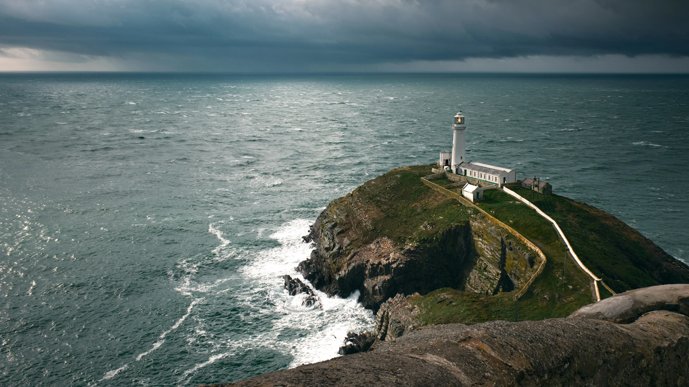 There's a strong chance this image contains the following subjects: water,  landscape,  sea,  rock,  lighthouse,  ocean,  seashore,  seascape,  anglesey,  wales. The photographer has provided the following description: South Stack Lighthouse is a historic lighthouse built by Trinity House in 1809 to mark a tiny islet off the coast of Holy Island, Anglesey, in Wales. Photographer_name: Chris Michael. Title: South Stack Lighthouse. The photographer has provided the following description: South Stack Lighthouse is a historic lighthouse built by Trinity House in 1809 to mark a tiny islet off the coast of Holy Island, Anglesey, in Wales. Make: fujifilm. Model: X-T5. Technical: 16-80mmm. Published: 2025-09-09 13:28:40