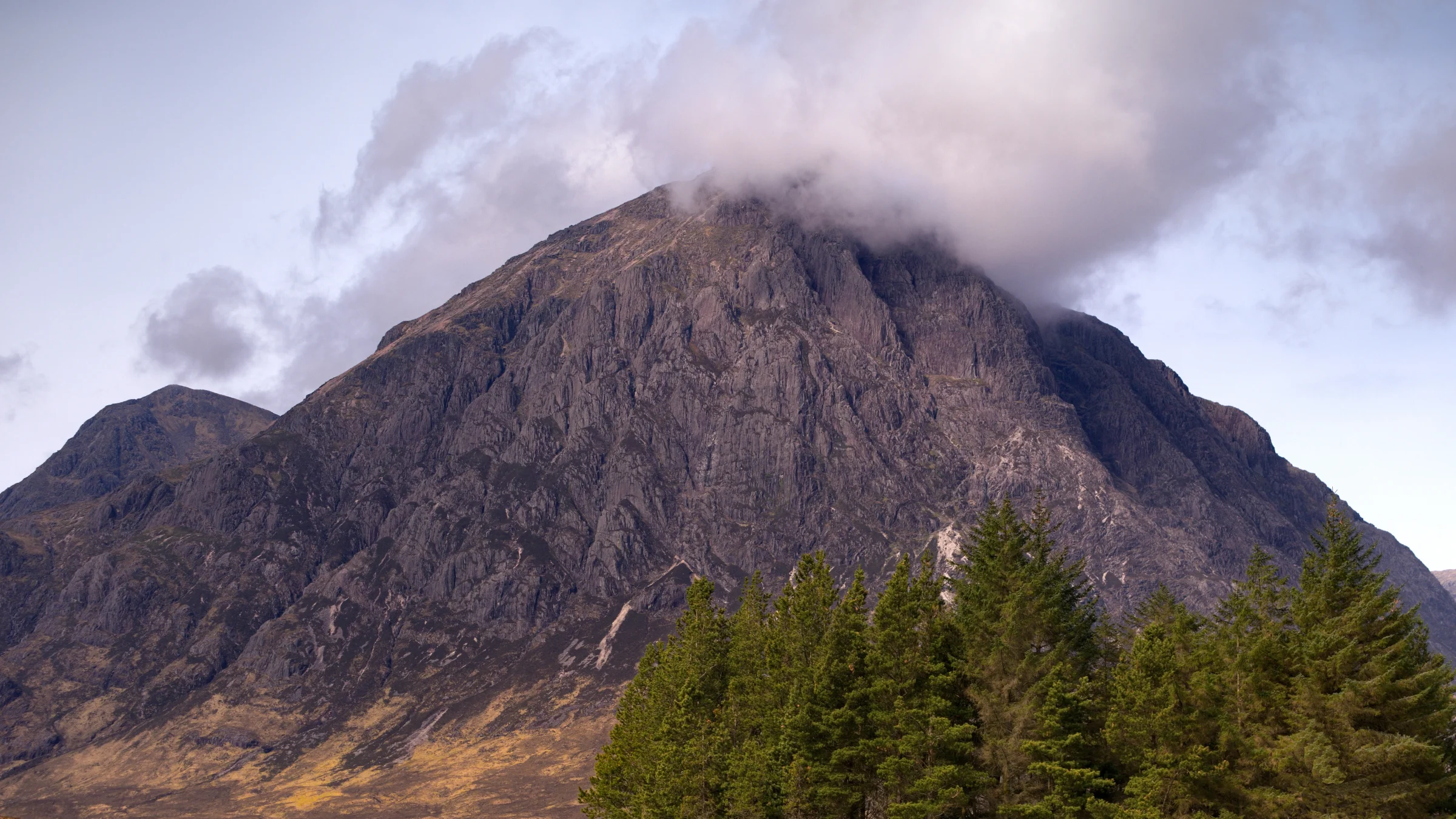 There's a strong chance this image contains the following subjects: fog,  landscape,  travel,  nature,  scotland,  highlands,  scottishhighlands,  trees,  buachailleetivemor,  glencoe. The photographer has provided the following description: The incredible 'buckle' in the Scottish Highlands. Photographer_name: Chris Michael. Title: Buachaille Etive Mor. The photographer has provided the following description: The incredible 'buckle' in the Scottish Highlands. Make: fujifilm. Model: X-T5. Technical: 16-80mm. Published: 2025-09-08 21:17:27