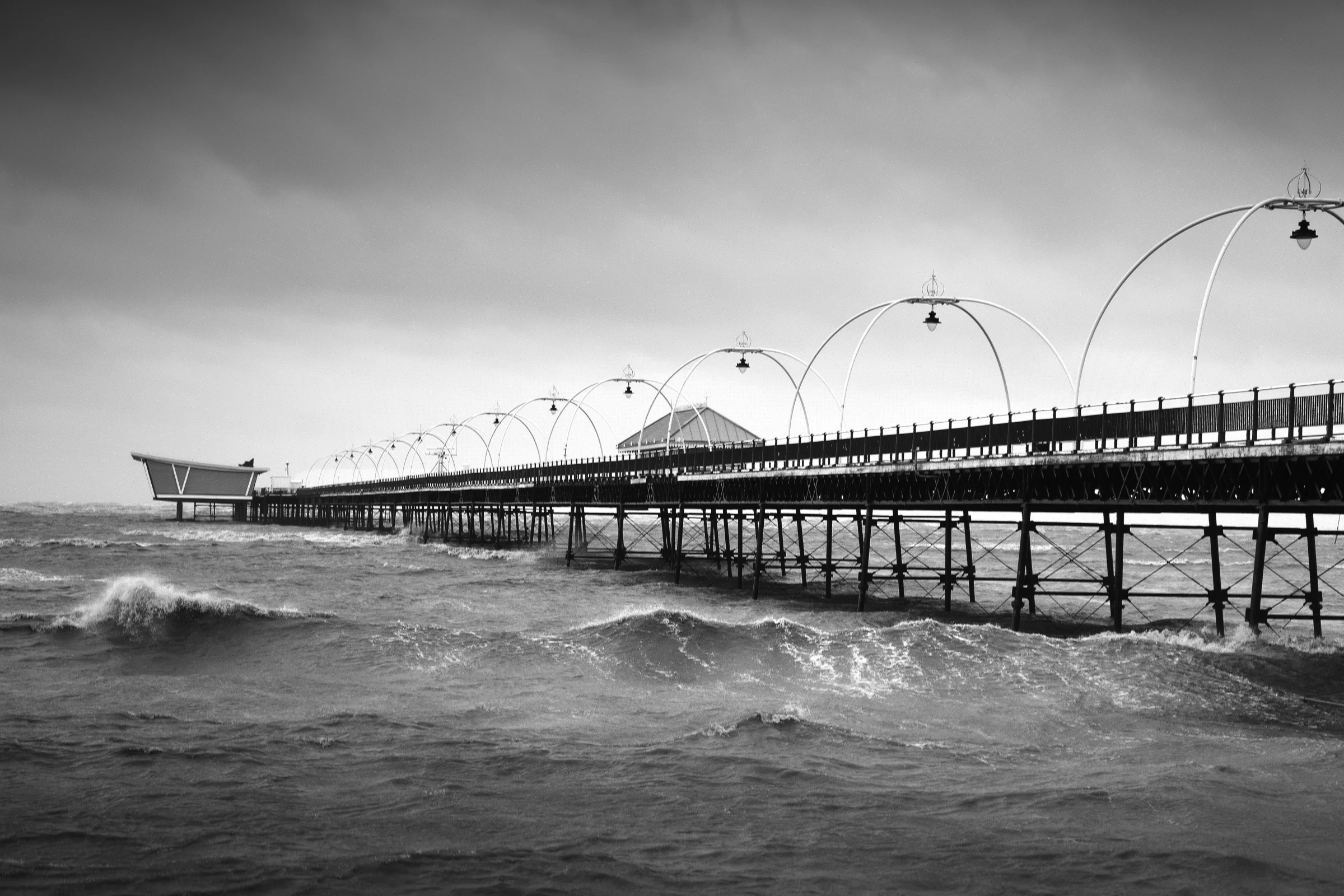 There's a strong chance this image contains the following subjects: monochrome,  water,  sea,  bridge,  ocean,  pier,  merseyside,  seashore,  blackandwhite,  seascape,  southport. The photographer has provided the following description: Taken in 2024 during Spring Tide. It's the first time I've ever noticed the sea come in so close! Photographer_name: Chris Michael. Title: Spring Tide in Southport. The photographer has provided the following description: Taken in 2024 during Spring Tide. It's the first time I've ever noticed the sea come in so close! Make: fujifilm. Model: X-T5. Technical: 16-80mm. Published: 2025-09-10 13:36:37