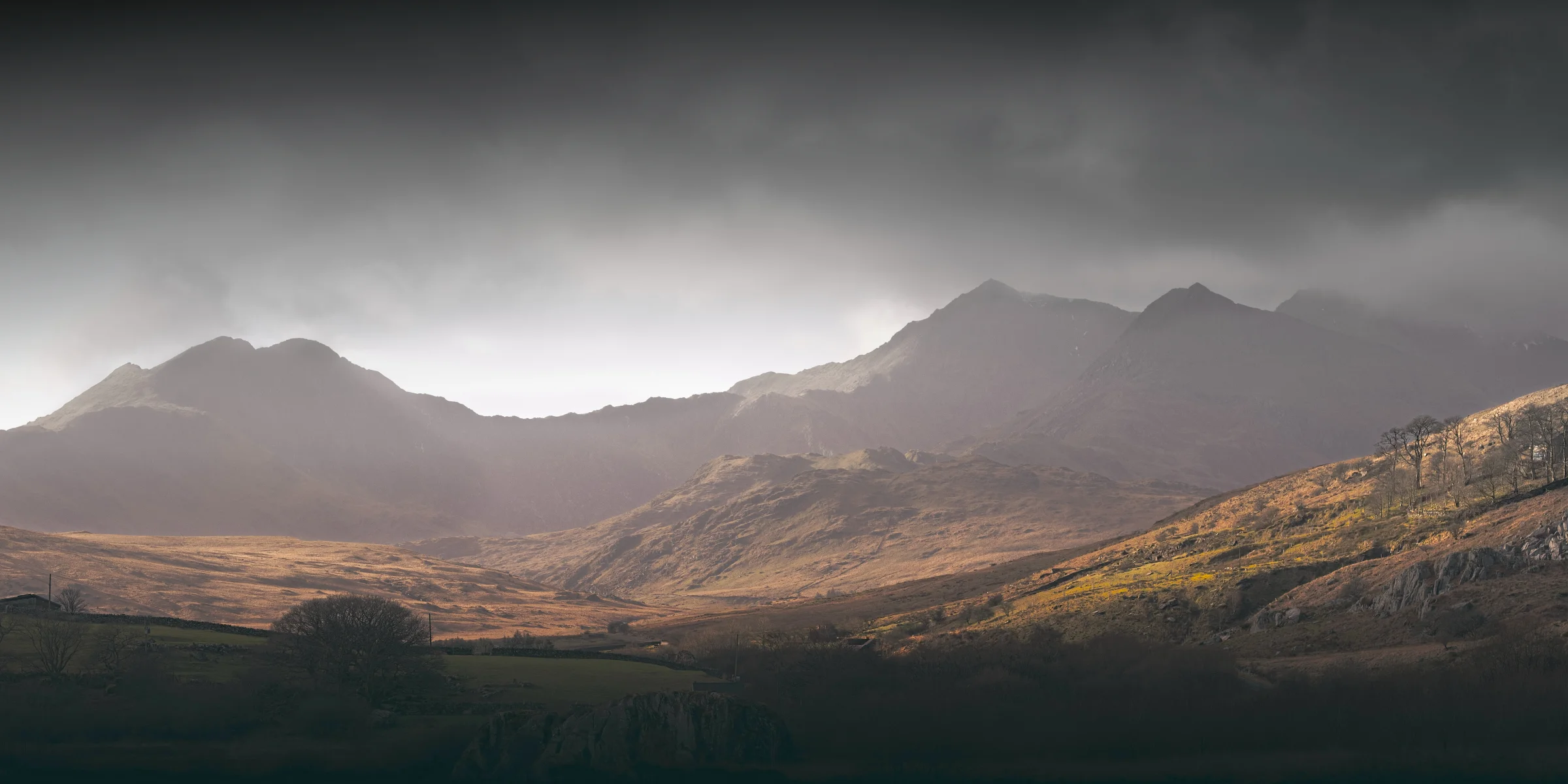 There's a strong chance this image contains the following subjects: landscape,  travel,  nature,  wales,  snowdonia,  eryri,  eryrinationalpark,  nationalpark,  snowdon. The photographer has provided the following description: The beautiful mountain that is Snowdon, as seen from Capel Curig during bad weather earlier in the year. Photographer_name: Chris Michael. Title: Snowdonia. The photographer has provided the following description: The beautiful mountain that is Snowdon, as seen from Capel Curig during bad weather earlier in the year. Make: fujifilm. Model: X-T5. Technical: 55-200mm. Published: 2025-09-09 14:09:23