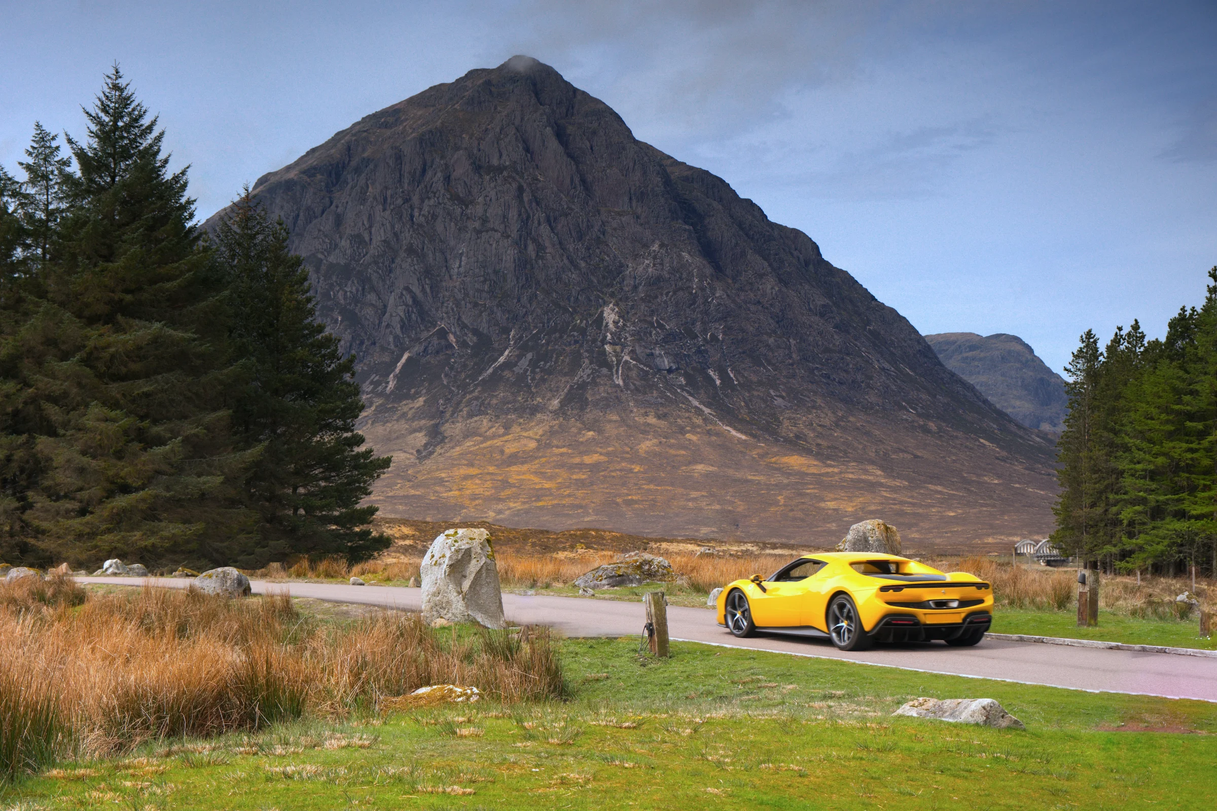 There's a strong chance this image contains the following subjects: landscape,  scotland,  scottishhighlands,  trees,  buachailleetivemor,  glencoe. The photographer has provided the following description: I was stood getting ready to photography the mountain Buachaille Etive Mor whilst outside the Kingshouse Hotel in Glencoe, when this Lotus supercar creeped into shot.... I'm glad it did! Photographer_name: Chris Michael. Title: The Supercar. The photographer has provided the following description: I was stood getting ready to photography the mountain Buachaille Etive Mor whilst outside the Kingshouse Hotel in Glencoe, when this Lotus supercar creeped into shot.... I'm glad it did! Make: fujifilm. Model: X-T5. Technical: 16-80mm. Published: 2025-09-08 21:19:58